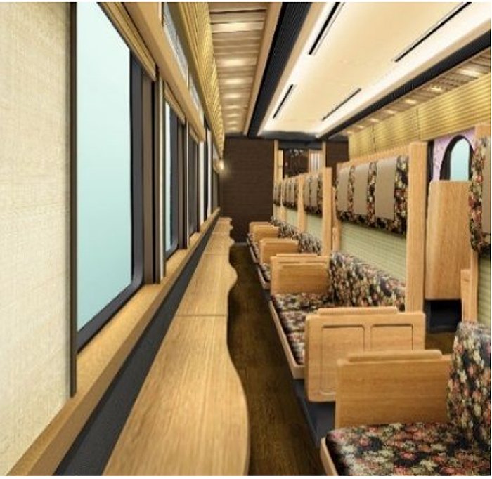 The interior of carriage 3. Carriages 3 and 4 have seats facing large windows so that passengers can enjoy an uninterrupted view of the Nishiyama mountain range.