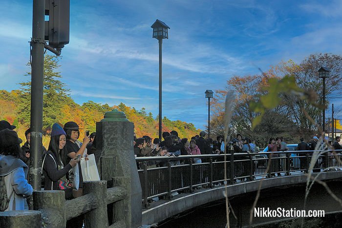 Tourists stop on the nearby public Nikko Bridge to view and photograph the Shinkyo Bridge