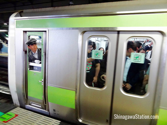 A Yamanote loop line train stops at JR Shinagawa Station