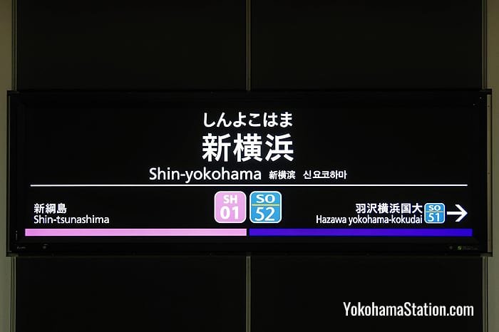 A station name sign at Shin-Yokohama Station. Sotetsu stations are color-coded blue and Tokyu stations are color-coded pink
